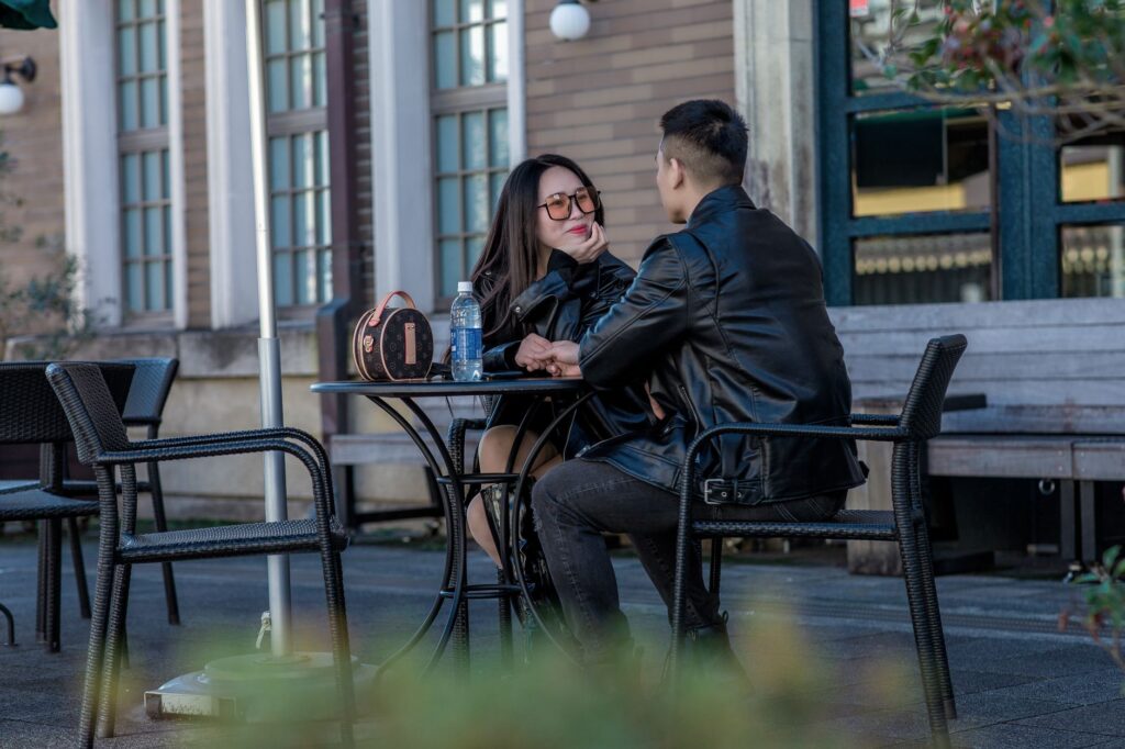 photo of a couple in leather jackets sitting on black chairs