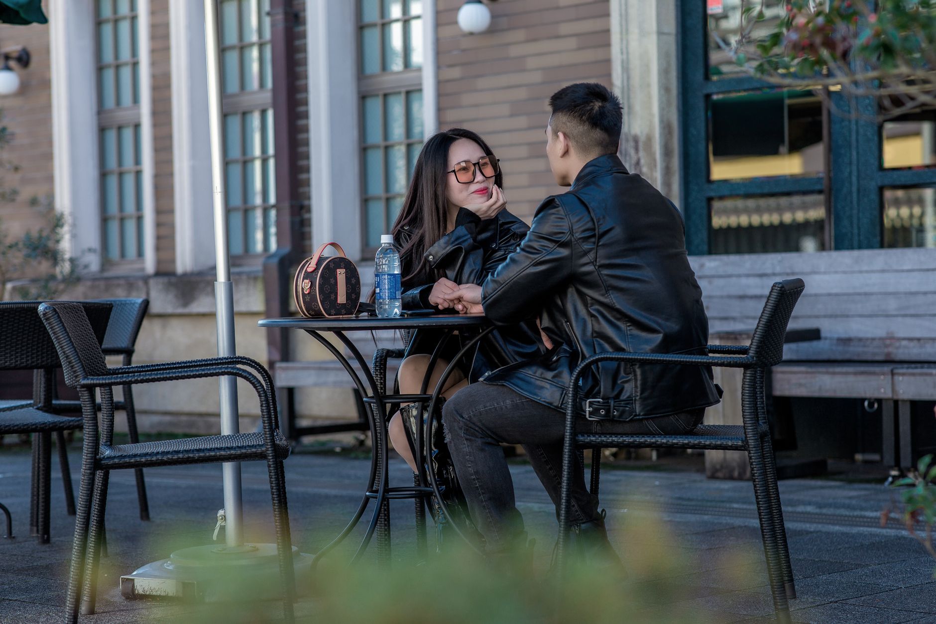photo of a couple in leather jackets sitting on black chairs