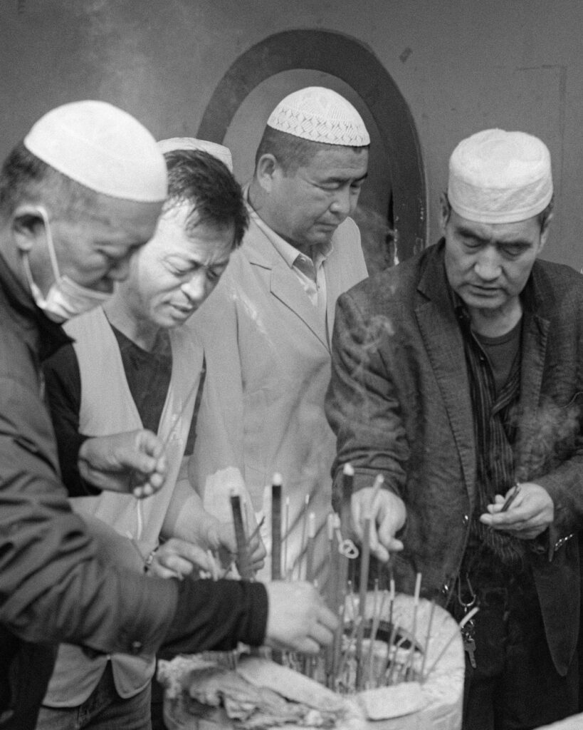 men offering incense prayers in ceremony